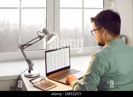 Back of a young businessman working with laptop computer at the office and typing. Stock Photo