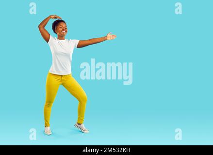 Portrait of funny young woman standing in martial arts pose isolated on turquoise background. Stock Photo