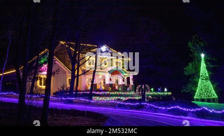 Beautiful Christmas lighting on a house and a lighted green Christmas tree on a winter evening in Taylors Falls, Minnesota USA. Stock Photo