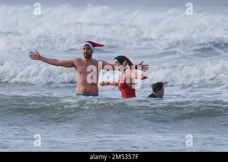 Polzeath, Cornwall, UK. 25th December 2022. UK Weather. Hundreds of people took to the sea at Polzeath this morning for the annual Christmas day swim. Credit Simon Maycock / Alamy Live News. Stock Photo