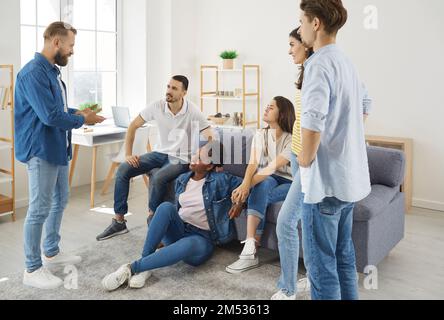 Group of young friends at home in living room having lively conversation during weekend meeting. Stock Photo