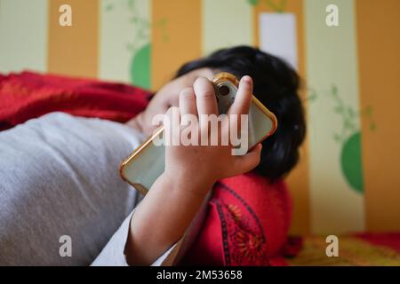 child using smart phone on bed  Stock Photo