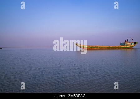 Landscape View of a small cargo ship against a blue sky on the  Padma river Bangladesh Stock Photo