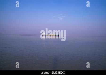 Landscape View of a small cargo ship against a blue sky on the  Padma river Bangladesh Stock Photo