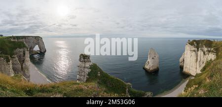 Panorama of the Alabaster coast with famous rock formations Manneporte, Porte d'Aval and l'Aiguille on a cloudy summer day, Etretat, Normandy, France Stock Photo