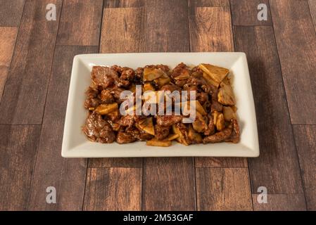 A Chinese food tray of chopped beef with bamboo and stewed mushrooms and oyster sauce Stock Photo