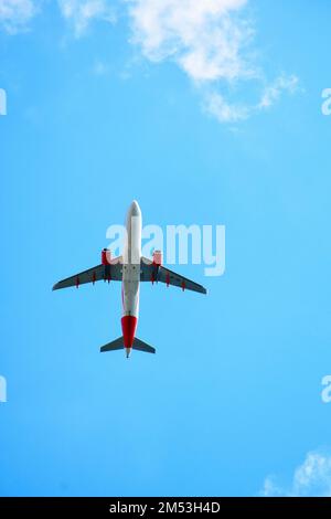 Airplane in flight. A view of the fuselage and the blue sky background Stock Photo