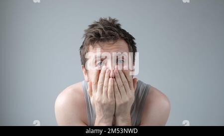 Scared caucasian guy shivering from fear, looking afraid and insecure at camera. Stock Photo