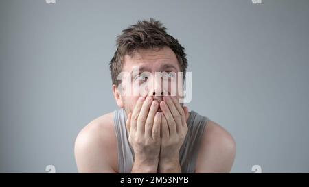 Scared caucasian guy shivering from fear, looking afraid and insecure at camera. Stock Photo