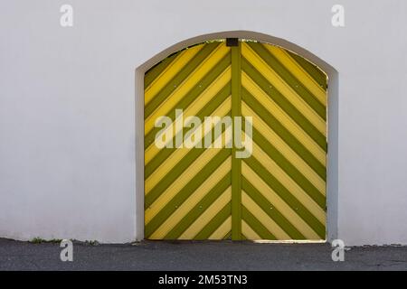 colorful wooden gateson white wall. external wooden entrance doors to houses or castle Stock Photo
