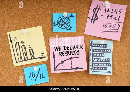 Business concept. On the board are stickers with graphs and diagrams and the inscription - WE DELIVER RESULTS Stock Photo