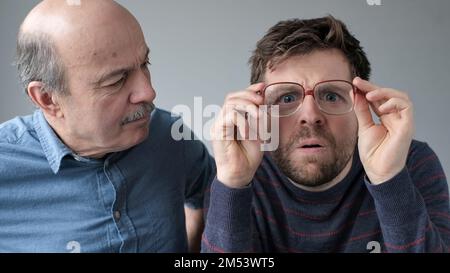 Surprised stupefied men mature father and son in big glasses with WOW expression Stock Photo