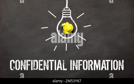 confidential information text on the card writes a person's hand next to a yellow notebook on a light background. Stock Photo
