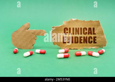 Medical concept. On the green surface of the tablet and a hand pointing to a sign with the inscription - Clinical Evidence Stock Photo