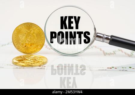 Business and technology concept. There are bitcoins on the chart and there is a magnifying glass with the inscription - KEY POINTS Stock Photo