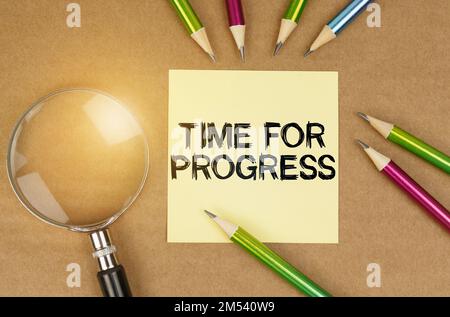 Education concept. On the table are pencils, a magnifying glass and a sticker with the inscription - Time for progress Stock Photo
