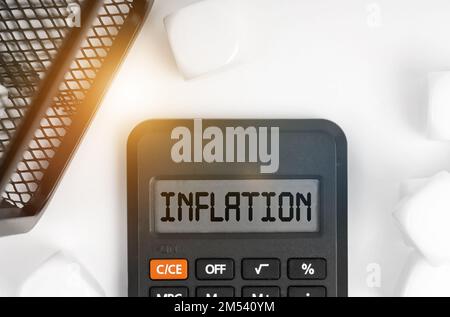 Business concept. On the table are white cubes, a black basket and a calculator with the inscription - Inflation Stock Photo