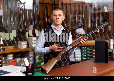 Gun shop salesman showing double barreled hunting rifle Stock Photo