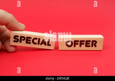 Business concept. On a red background, wooden blocks, one of them in hand. The blocks are written - SPECIAL OFFER Stock Photo