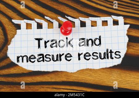 Business concept. Attached to the board is an announcement with the inscription - Track and measure results Stock Photo
