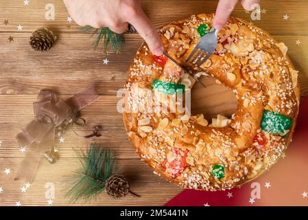 Splitting a "Roscon de Reyes" typical Spanish Epiphany dessert eaten at Christmas time Stock Photo