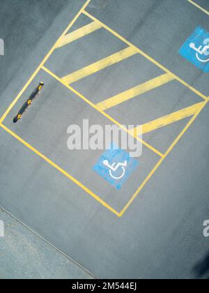 Disabled parking space aerial view with yellow lines and asphalt texture showing handicapped sign. Stock Photo