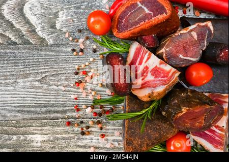 Close up of assorted dry-cured meat on the wooden background Stock Photo