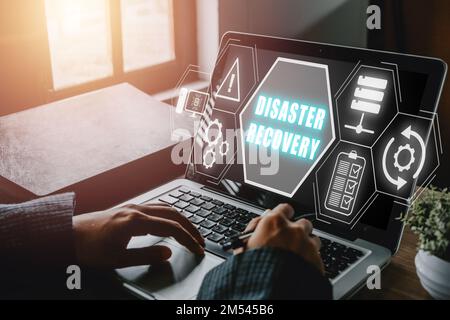 Disaster Recovery concept, Person hand using laptop computer with Disaster Recovery icon on virtual screen. Stock Photo