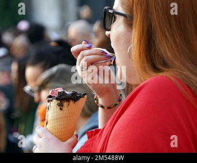 Rome, Italy. 25th Dec, 2022. A woman eats ice cream on Christmas Day in Rome, Italy, on Dec. 25, 2022. Italy is expected to have its warmest holiday season in at least 50 years, according to meteorologists, more anomalous weather in a year filled with unusual weather patterns. Credit: Jin Mamengni/Xinhua/Alamy Live News Stock Photo