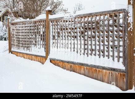 Snow on a wooden fence. Rural house with a fence in winter. Village after snowfall. Covered with snow wooden fence. Nobody, street photo Stock Photo