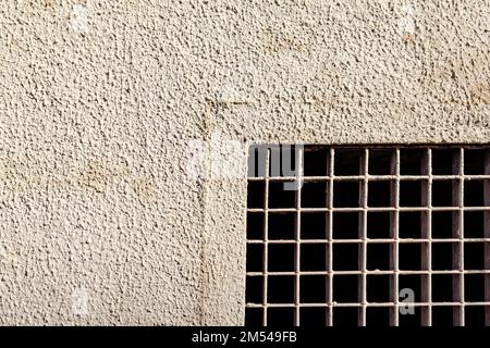 Metal grating in stone wall . Prison window with grates Stock Photo