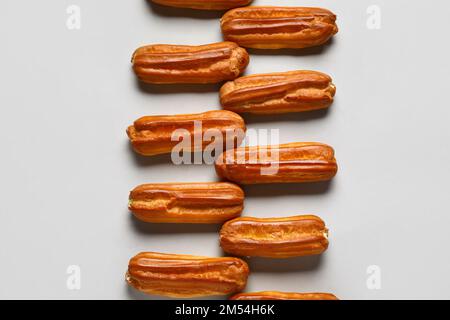 Composition with sweet eclairs on light background Stock Photo