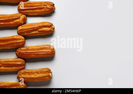 Composition with sweet eclairs on light background Stock Photo