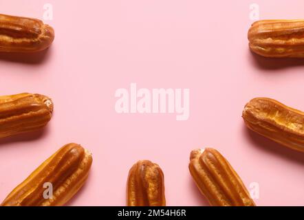 Composition with sweet eclairs on pink background Stock Photo