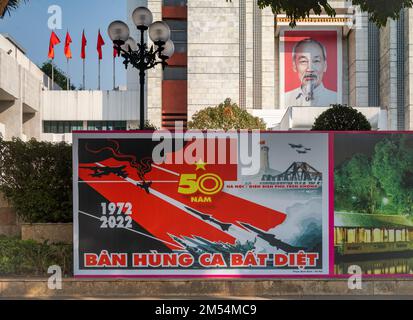 A Communist party propaganda poster in from of a large portrait of President Ho Chi Minh on the front of the Hanoi People's Committee building in the Stock Photo