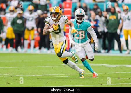 Miami. FL USA;  Green Bay Packers wide receiver Christian Watson (9) makes a reception and runs with the ball while pursued by Miami Dolphins cornerba Stock Photo
