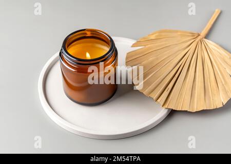 Handmade candle from paraffin and soy wax in glass jar on concrete tray. Candle making. Minimalism. Luxurious white tray decoration, home interior dec Stock Photo