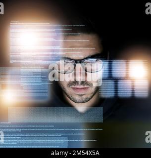 Coding is second nature to him. a focussed young computer programmer working on his coding late at night. Stock Photo