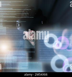 Coding in the virtual world. a young computer programmer wearing a vr headset while working on his code. Stock Photo