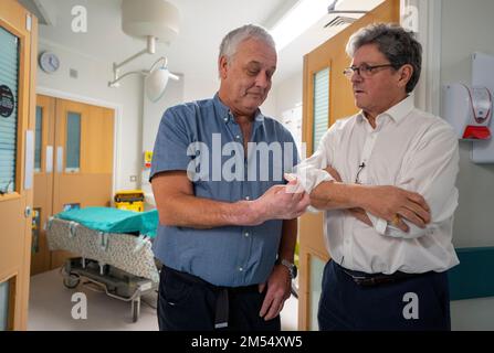 Mark Cahill, who was the first person in the UK to have a hand transplant in 2012, with Surgeon Simon Kay, at Leeds General Infirmary, West Yorkshire, to mark the 10th anniversary of the UK's first hand transplant. Picture date: Tuesday December 20, 2022. Stock Photo