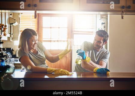 Fooling around is all part of the fun. a young couple having fun while doing chores together at home. Stock Photo