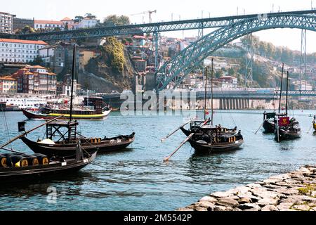 Traditional boats on Rio Douro. Portugal old town cityscape and Dom Luis I bridge in Porto, Portugal. Stock Photo