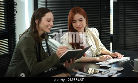 Smiling business coworkers planning marketing strategy, discussing over new business project at modern office Stock Photo