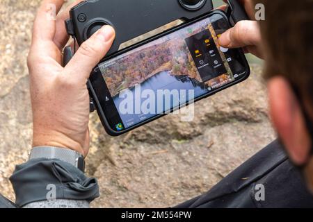 Man flying drone over Monticolo lake in South Tyrol, Appiano, Bolzano province, Trentino Alto Adige, northern Italy- Europe Stock Photo