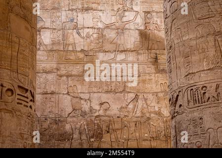 Hieroglypic painted carvings on wall at the ancient egyptian temple in Luxor. Egypt. Stock Photo