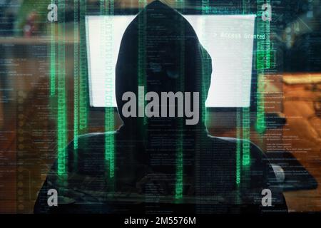 Hes got his eyes on your personal information. Rearview shot of an unidentifiable hacker cracking a computer code in the dark. Stock Photo