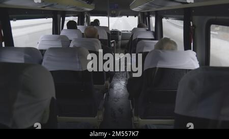 Minibus with passengers on the move in winter. Stock Photo