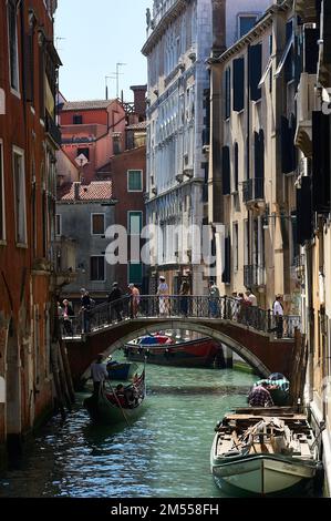 Small bridge with tourists on Venetian canal, Venice, Italy Stock Photo