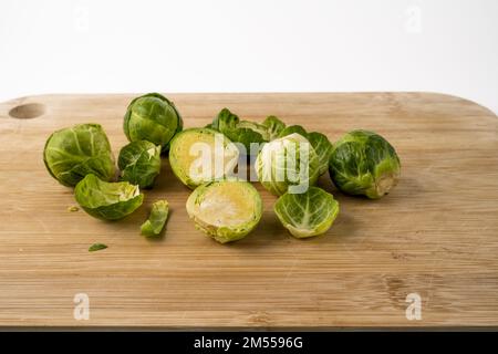 brussel sprouts being prepared on a bamboo chopping board Stock Photo