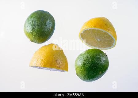halved lemons and whole limes isolated on a white background Stock Photo